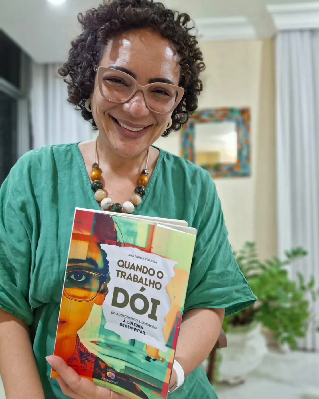 Dra. Ana Paula Teixeira segurando o livro Quando o Trabalho Dói