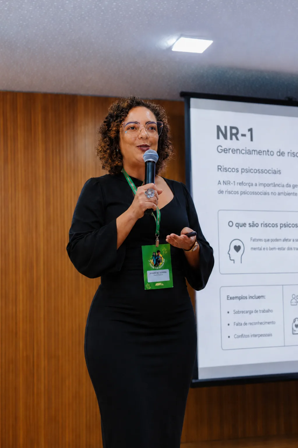 Dra. Ana Paula Teixeira em painel sobre NR-1, ao lado do slide