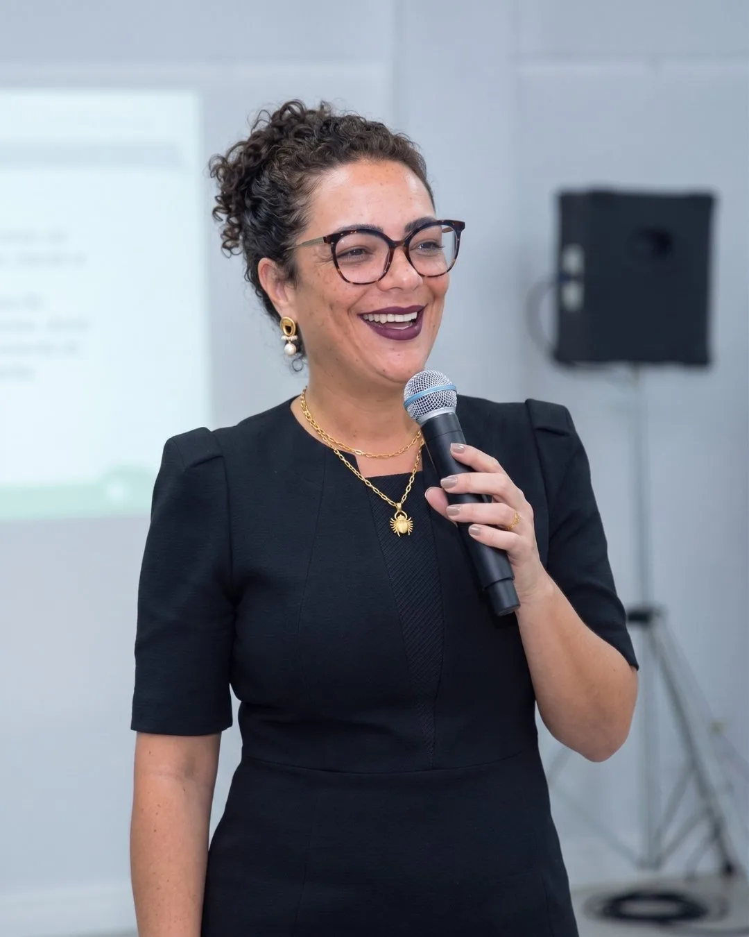Dra. Ana Paula Teixeira sorrindo em palestra corporativa sobre saúde mental no trabalho