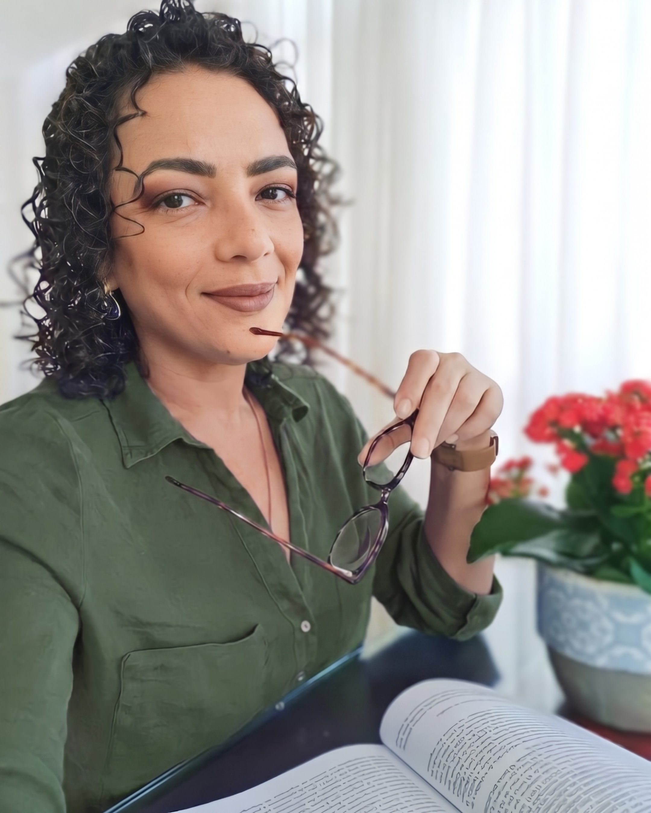 Dra. Ana Paula Teixeira lendo e segurando óculos